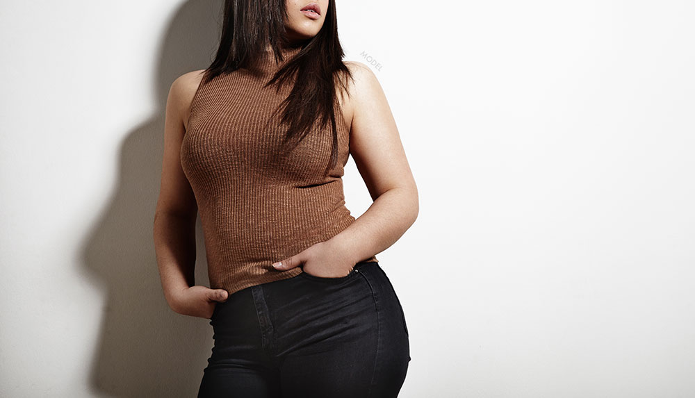 Female model in a turtle neck and hands in her black pant pockets