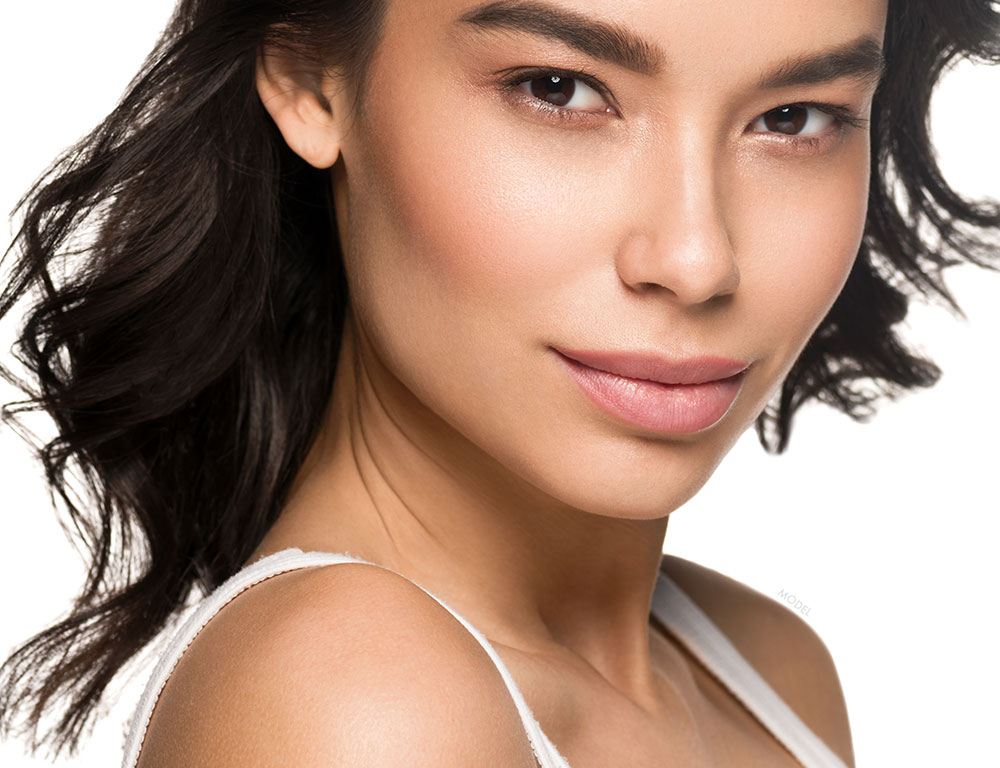 Close up headshot of a woman with defined features and hair blowing back