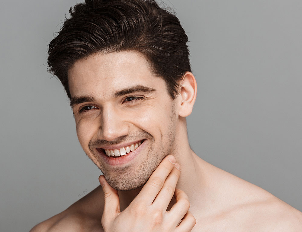 Headshot of a man examining his jawline