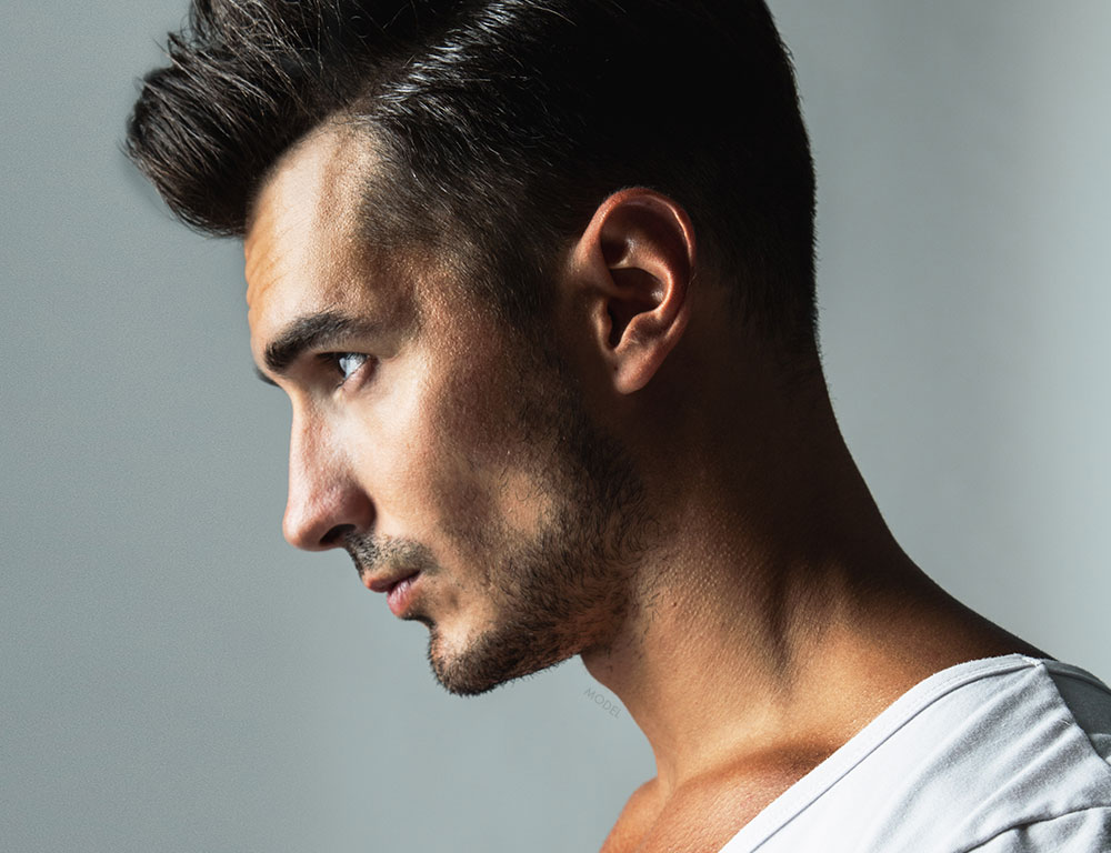 Profile headshot of a man with sculpted facial features