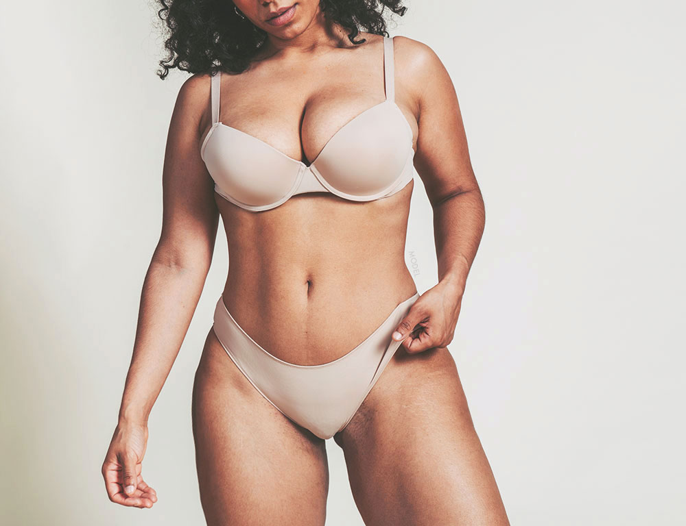 A voluptuous woman in nude colored undergarments